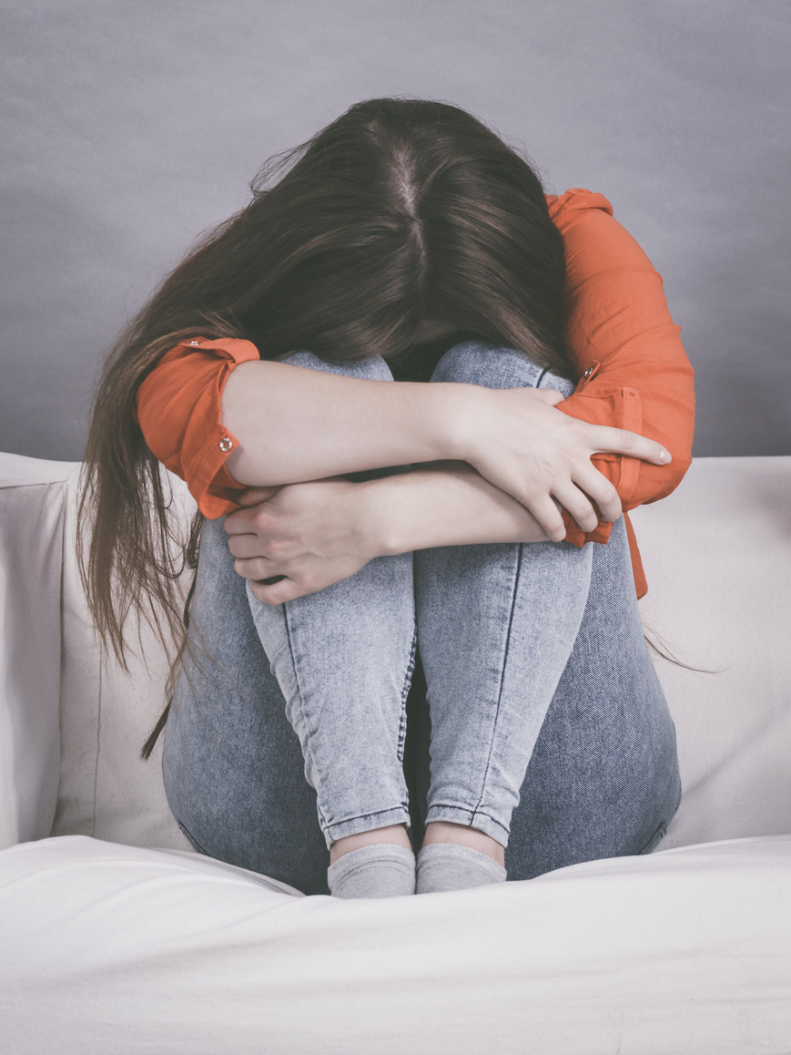 Worried woman sitting on sofa